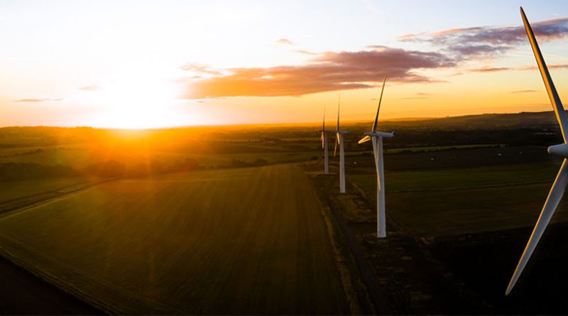 Wind turbines running across rural UK countryside creating electricity