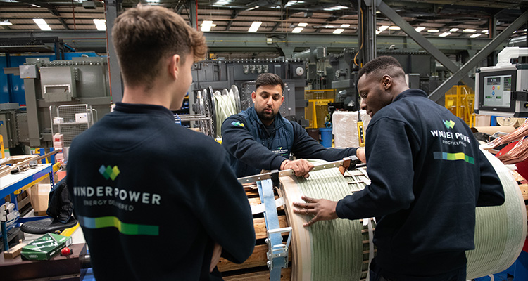 workers in an industrial setting, likely a factory or workshop, engaged in the manufacturing or assembly of large-scale equipment