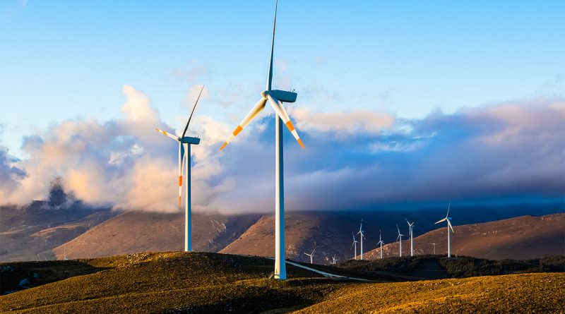 Wind turbines and solar battery storage system set in the Italian countryside, symbolizing renewable energy investment in Southern Europe.